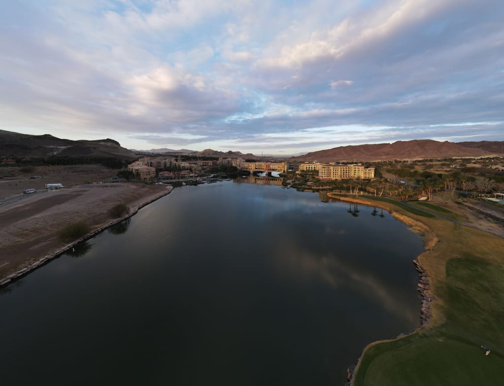 Clouds reflected on Lake Las Vegas with waterfront buildings and surrounding hills