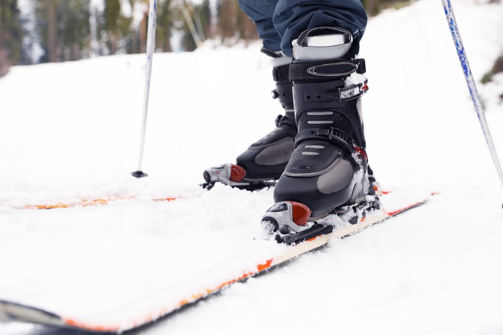 Close view of ski boots clipped into skis on fresh snow