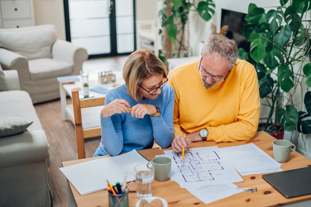 A couple reviewing house plans together at a wooden table