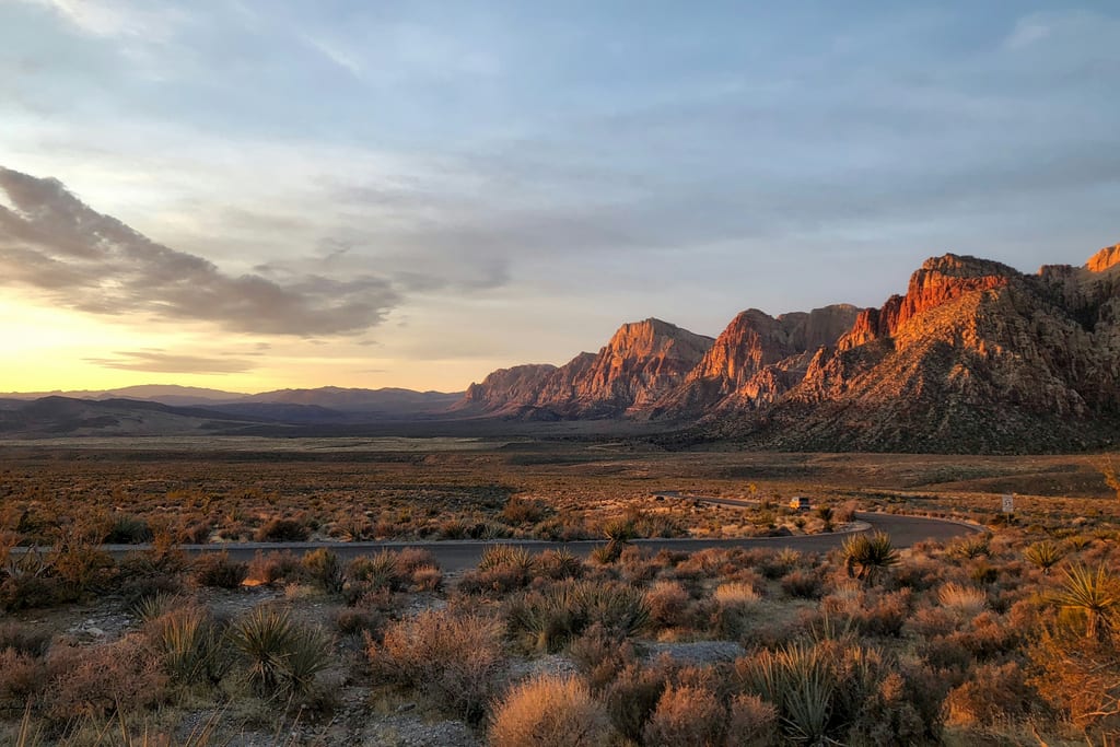 Red Rock Canyon’s red and gray cliffs at sunset above the desert on the valley’s western edge