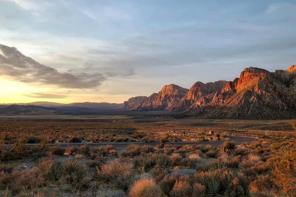 Red Rock Canyon’s red and gray cliffs at sunset above the desert on the valley’s western edge