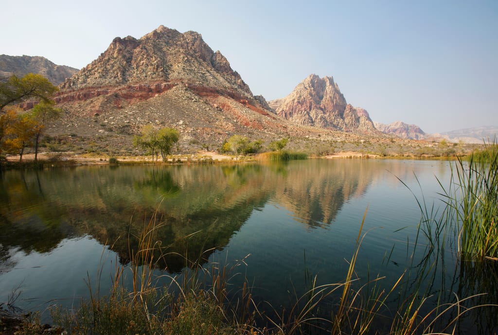 Sandstone cliffs reflected in the still water at Spring Mountain Ranch State Park