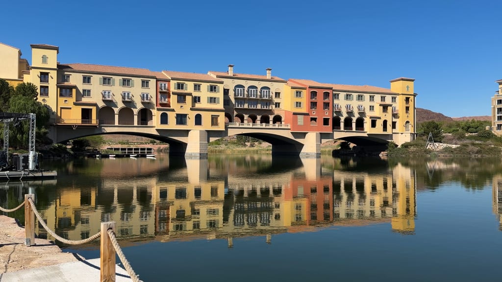 Sunlit buildings on an arched bridge reflected in Lake Las Vegas