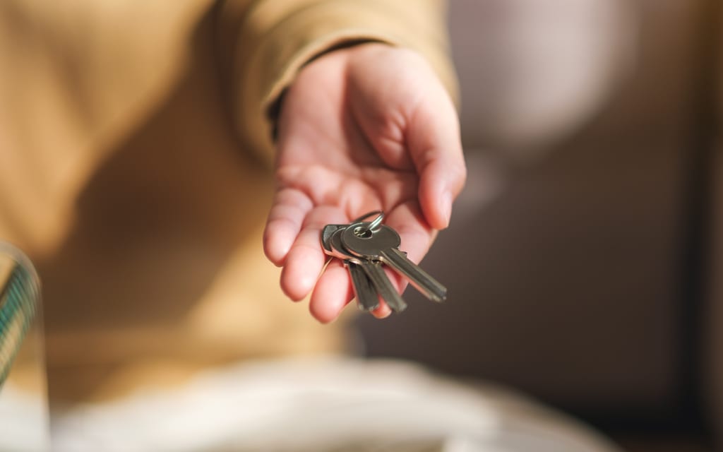 A hand holding a set of house keys.
